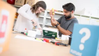 Tres persona de pie alrededor de una mesa